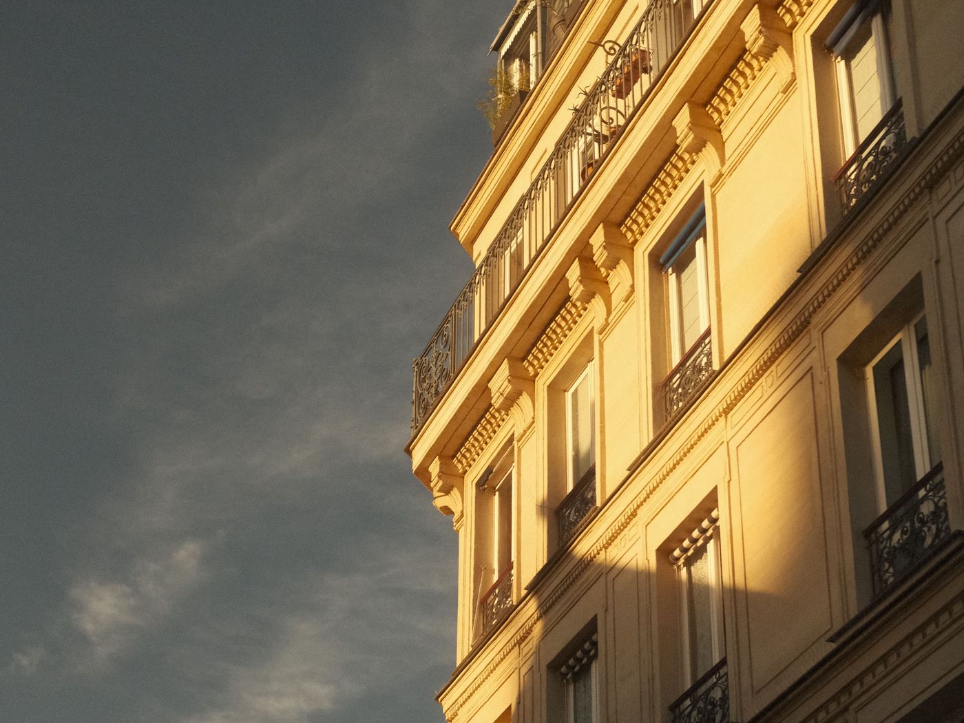Façade d’un immeuble haussmannien en pierre au soleil couchant
